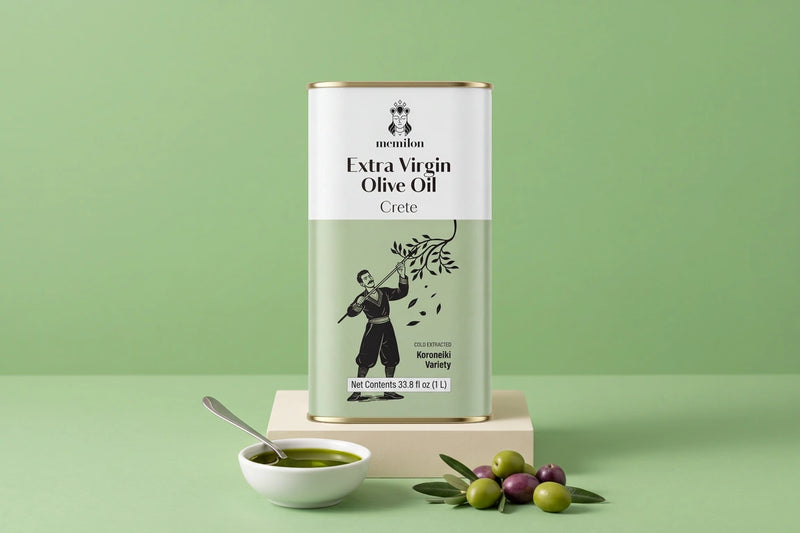 Cold pressed olive oil: Memilon Crete extra virgin olive oil tin on a cream plinth beside a bowl of olive oil and fresh olives