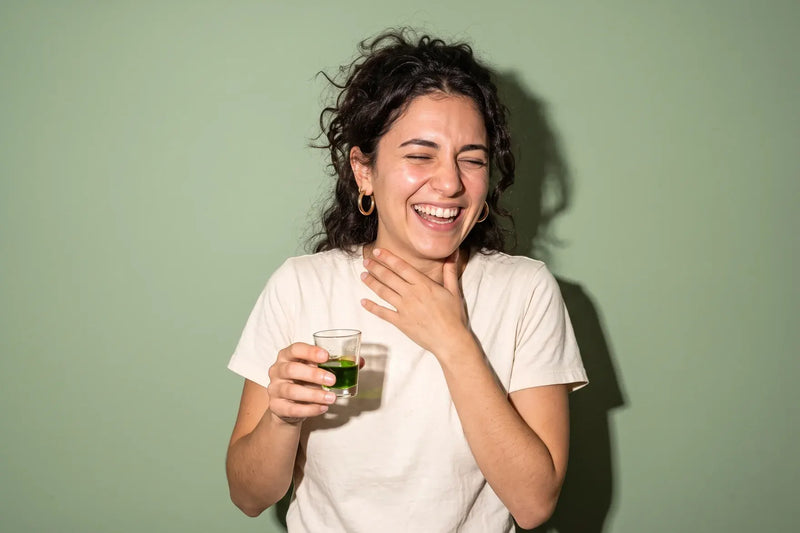 Woman laughing at the peppery throat catch of a high polyphenol Greek extra virgin olive oil